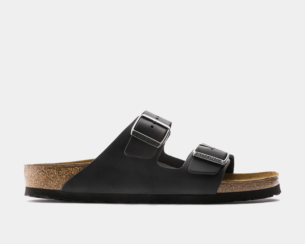A black Birkenstock Arizona sandal with two adjustable straps and a contoured cork-latex footbed.