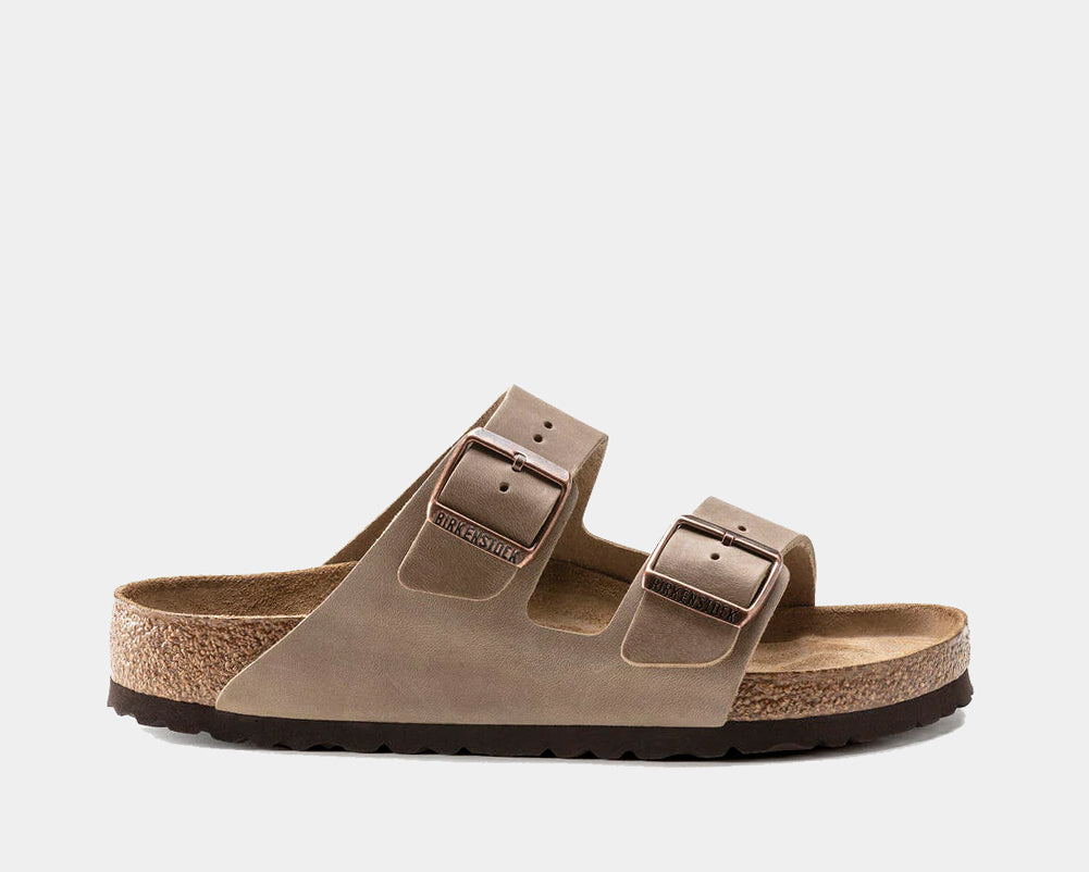 A pair of brown Birkenstock Arizona soft footbed sandals with oiled leather upper and two adjustable straps.