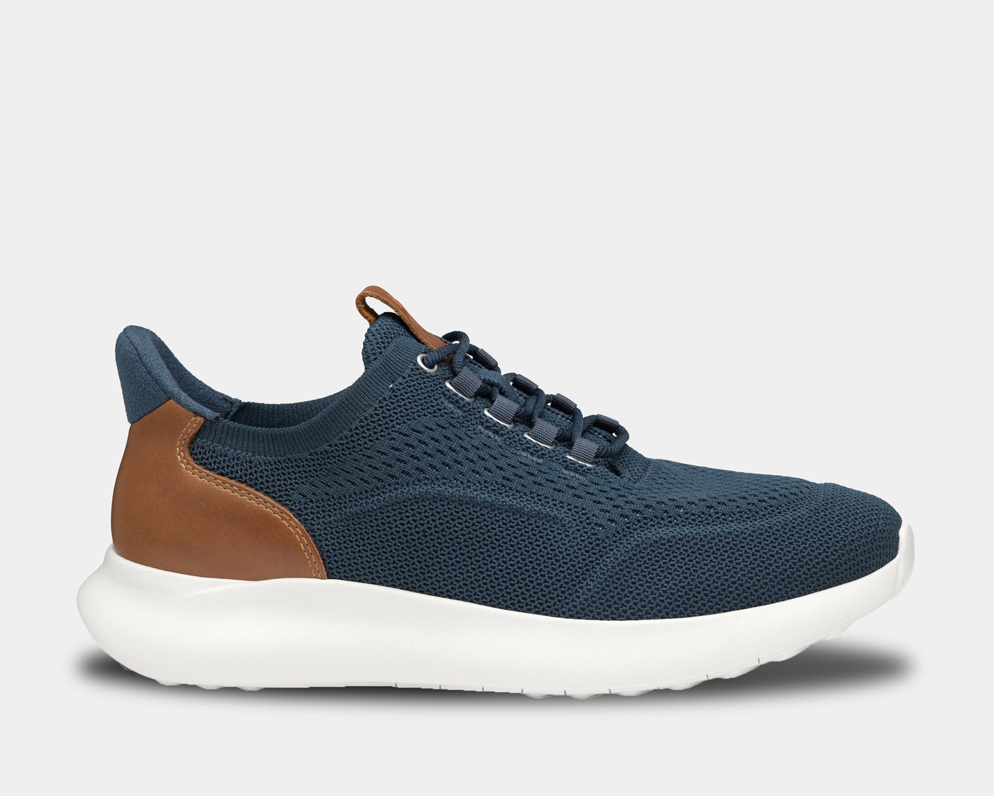 A pair of low-top athletic style knit sneakers with a plain toe design, featuring a navy knit fabric, brown leather trim, and a tan heel counter.